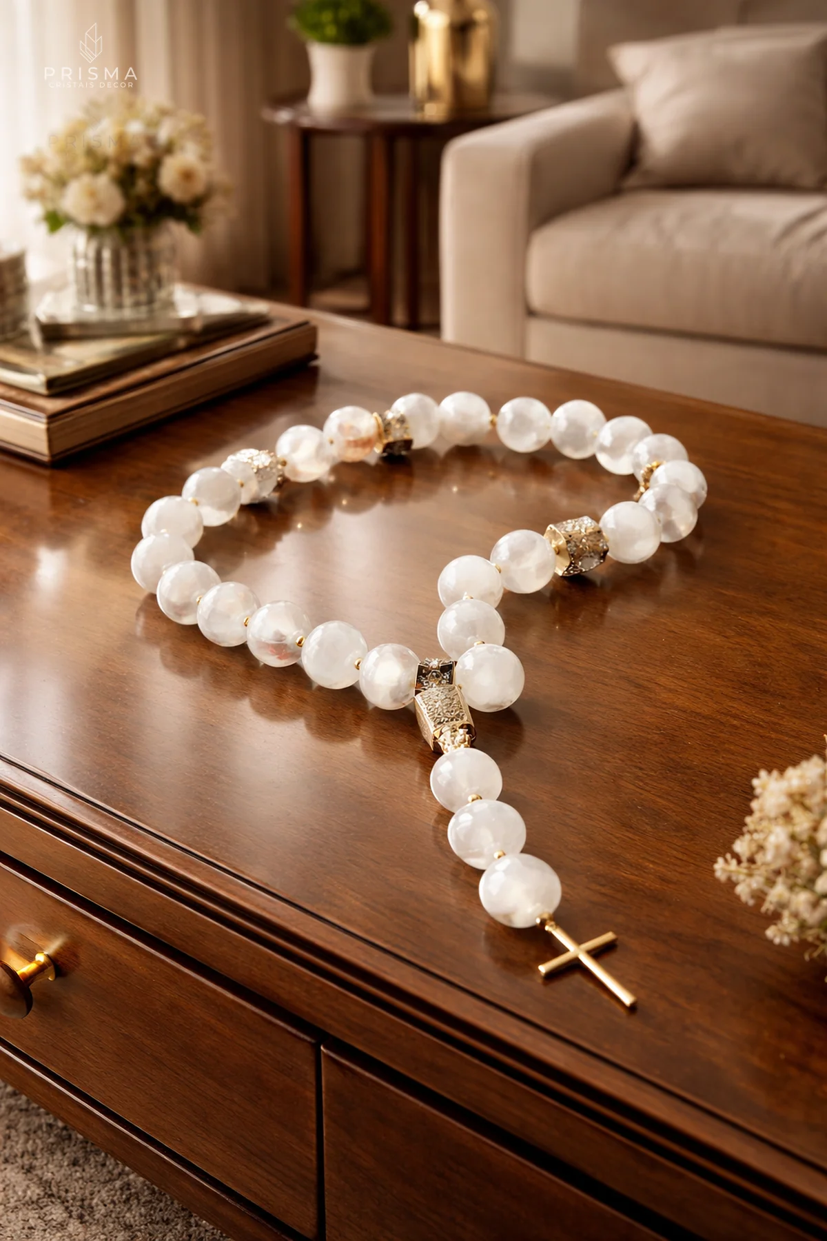 Terço de selenita branca sobre mesa de madeira em sala de estar sofisticada — decoração sacra contemporânea Santo Agostinho BH