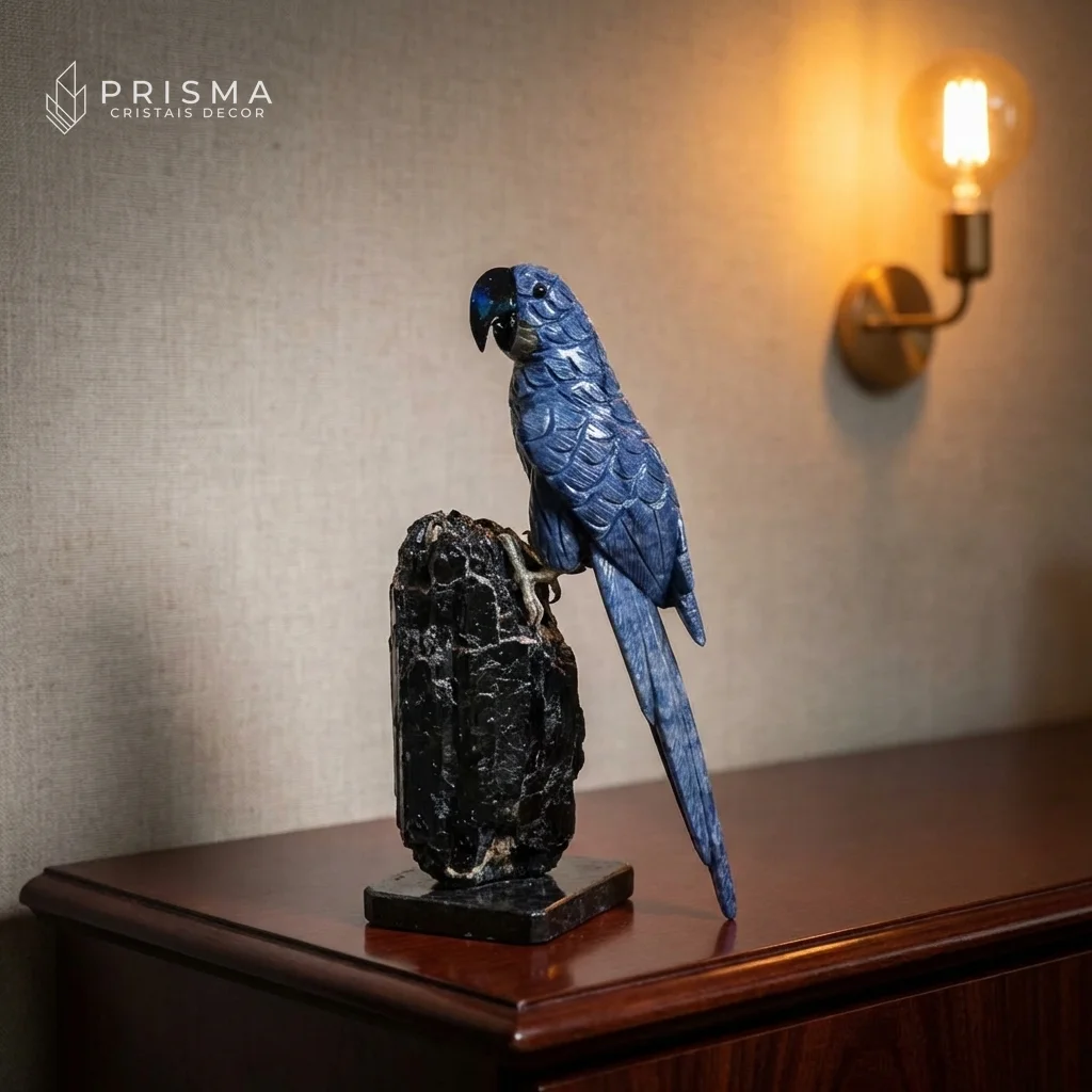 Arara em Quartzo Azul sobre console de madeira escura com luminária âmbar — escultura em cristal natural premium decoração alto padrão Nova Lima