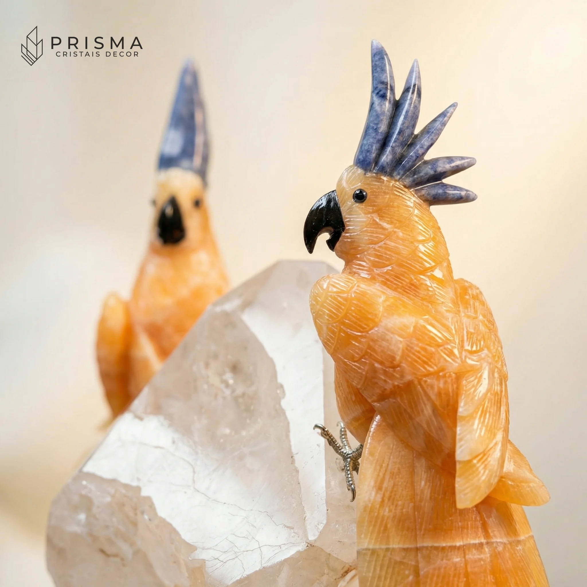 Detalhe artesanal das cacatuas em calcita laranja mexicana com penacho em sodalita azul — textura das penas lapidadas à mão