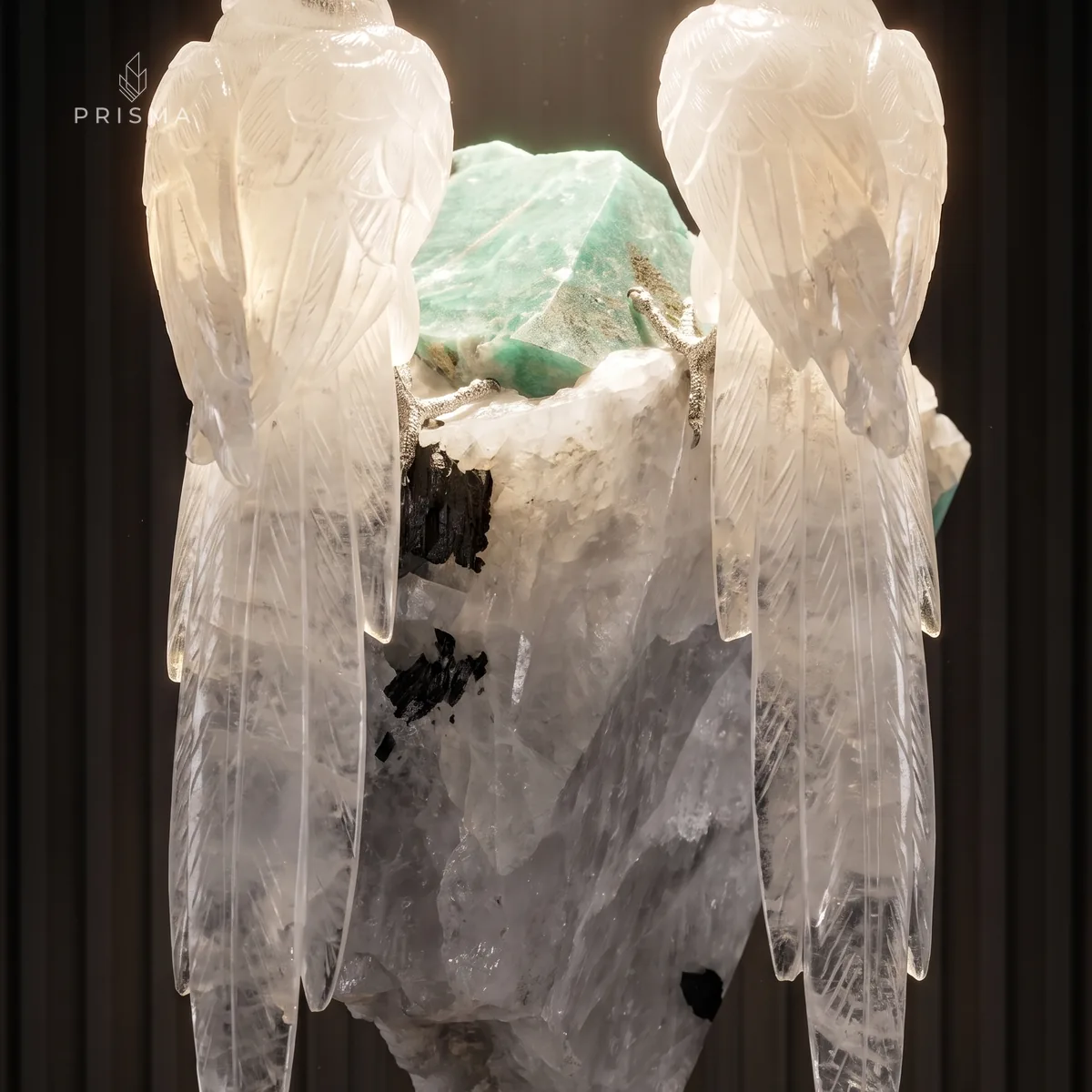 Caudas das araras em quartzo semitranslúcido iluminadas por trás, ao lado de pontos de turmalina negra